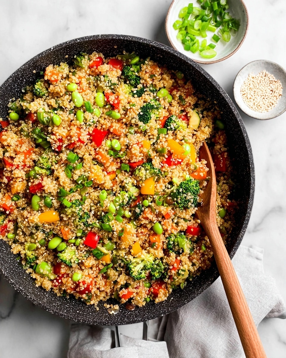 A large black speckled pan filled with mixed quinoa and vegetables sits on a white marbled surface. The dish shows a colorful mix of small, light tan quinoa grains layered with chopped green broccoli florets, bright red and yellow bell pepper pieces, orange carrot cubes, green edamame beans, and light green chopped green onions scattered on top. A wooden spoon is placed inside the pan on the right side, resting in the quinoa mixture. To the upper right of the pan, there are two small white bowls, one filled with sliced green onions and the other with white sesame seeds. The overall texture looks soft but with some crunch from the vegetables. Photo taken with an iphone --ar 4:5 --v 7
