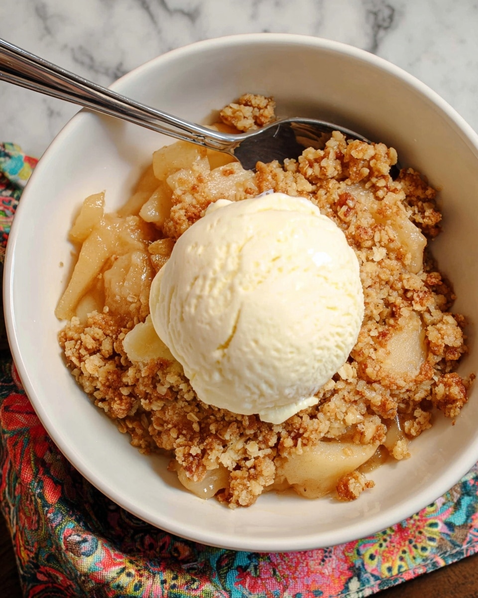 A close-up view of a baked apple crisp in a clear glass square dish, showing two main layers; the bottom layer is soft, cooked apple slices in a golden syrup, which looks juicy and slightly shiny, while the top layer is a thick, crumbly topping with a light brown, crunchy texture that covers the entire surface and is uneven and rough. The dish is placed on a white marbled surface. photo taken with an iphone --ar 4:5 --v 7