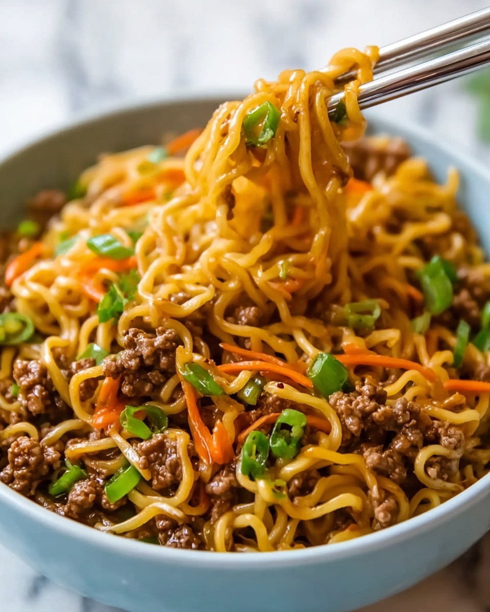 A close-up view of a bowl filled with cooked noodles coated in a glossy brown sauce, mixed with small pieces of cooked ground meat in the center and red bits of vegetables scattered around. Bright green chopped scallions are sprinkled on top, adding a fresh contrast. Black chopsticks lift a portion of the noodles and meat from the bowl, showing the texture of the tender meat and curled noodles. The bowl is white, placed on a white marbled surface, creating a clean look. photo taken with an iphone --ar 4:5 --v 7