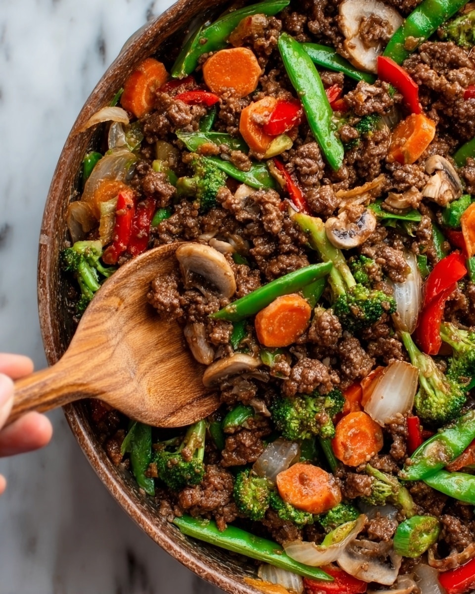 A close-up of a white plate filled with three layers: the bottom layer is white rice, topped with a colorful stir-fry mix as the second layer, featuring brown cooked ground beef, bright green broccoli florets, green snap peas, red bell pepper pieces, orange carrot slices, and light brown mushroom pieces, all coated in a shiny dark sauce. In the background, there is another white bowl with more stir-fry and a small dish with red chili flakes on a white marbled surface. Photo taken with an iphone --ar 4:5 --v 7